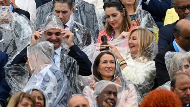 Ολυμπιακοί Αγώνες 2024, τελετή έναρξης: Τα πειράγματα της Μαρέβας στον Μητσοτάκη εν μέσω... βροχής - Οι φωτογραφίες του πρωθυπουργικού ζεύγους με αδιάβροχο